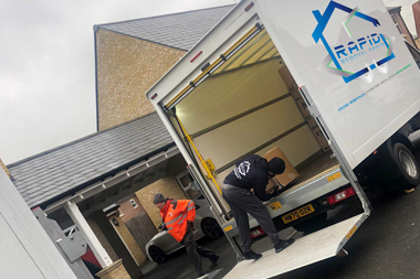 Removals company in London. Mover carrying goods out of van.